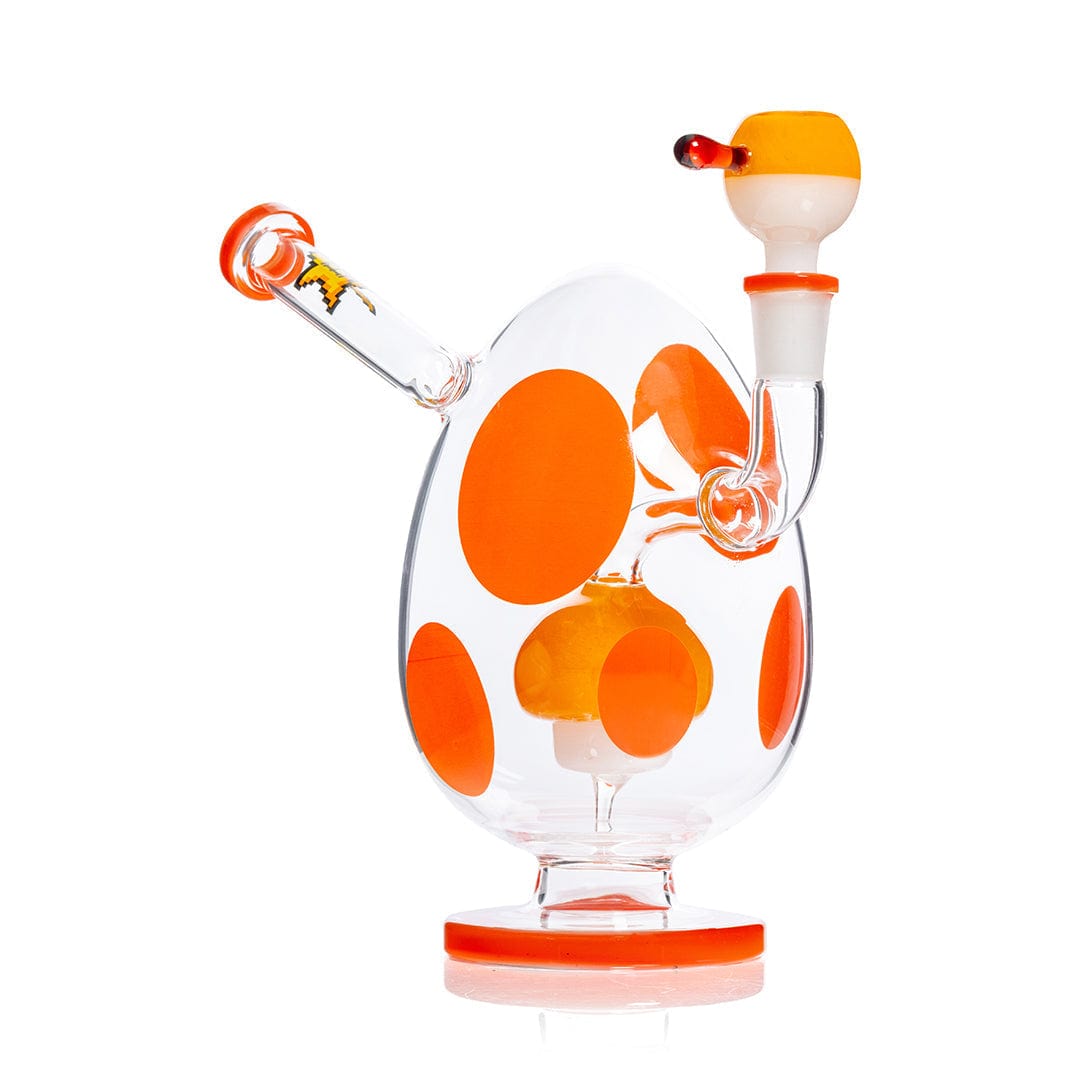 Three-quarter view of the Hemper Spotted Egg XL Bong showing its egg-shaped clear glass body with large orange spots, angled mouthpiece, and matching orange-accented bowl.