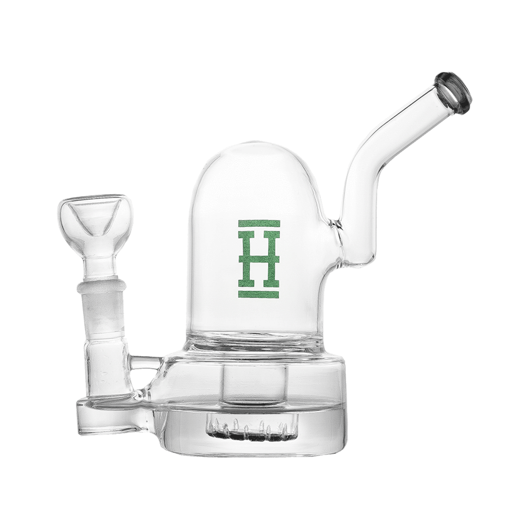 Side view of the Hemper Bell Rig, a small clear glass water rig with a domed chamber, angled mouthpiece, and green "H" logo.