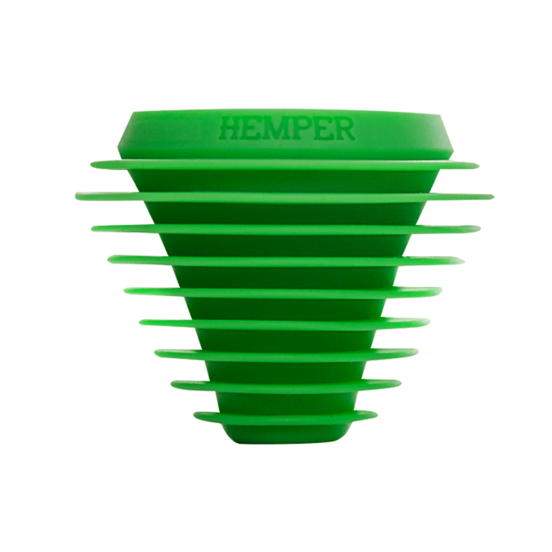 A close-up shot of the HEMPER Tech Cleaning Plugs+Caps, showing the dark green silicone design against a plain white backdrop.
