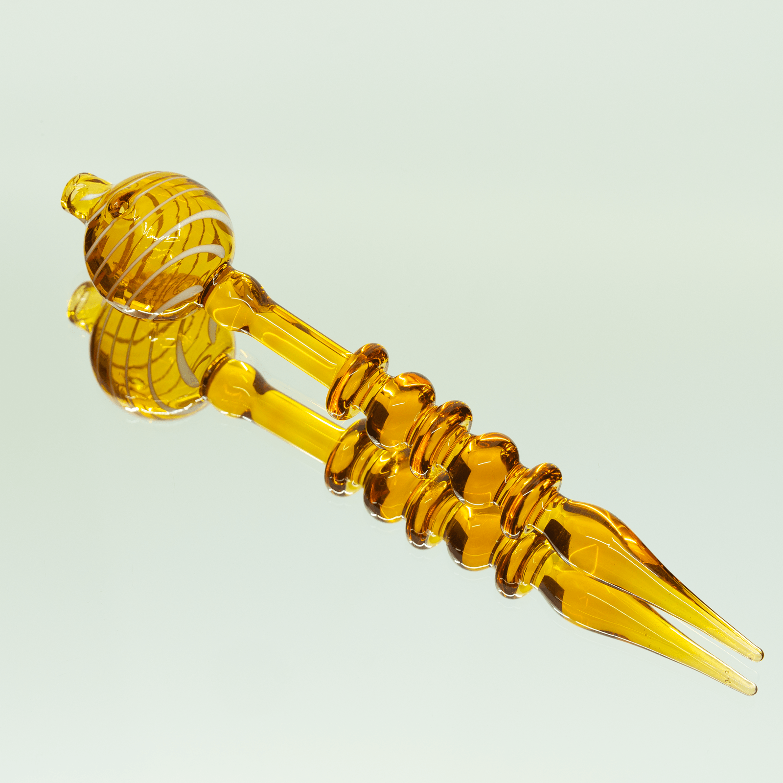 Close-up of the Bubble Head Dab Tool & Carb Cap, showing its curved, amber-colored design against a neutral backdrop.
