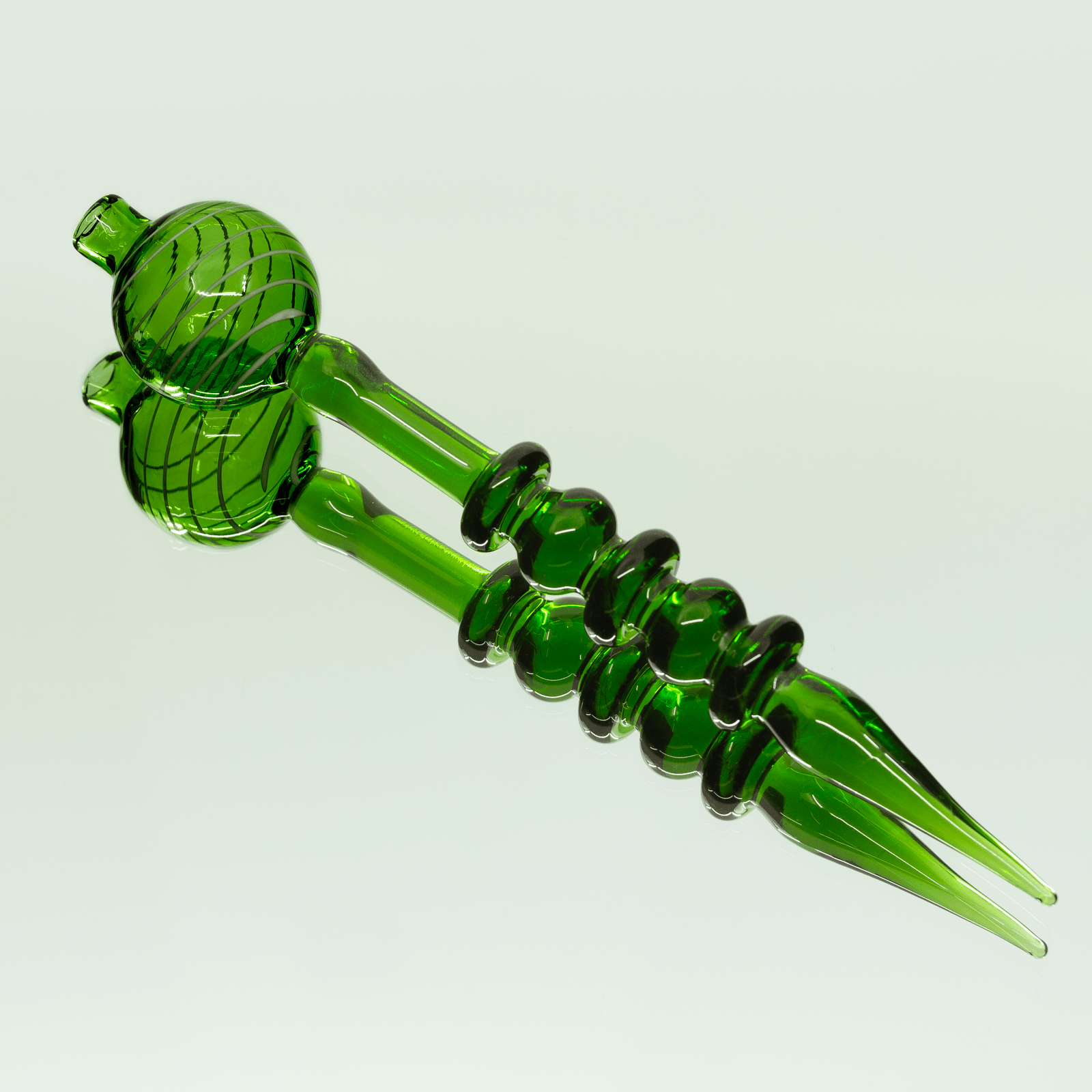 A close-up, angled view of the Bubble Head Dab Tool & Carb Cap with a rounded head and slender stem.