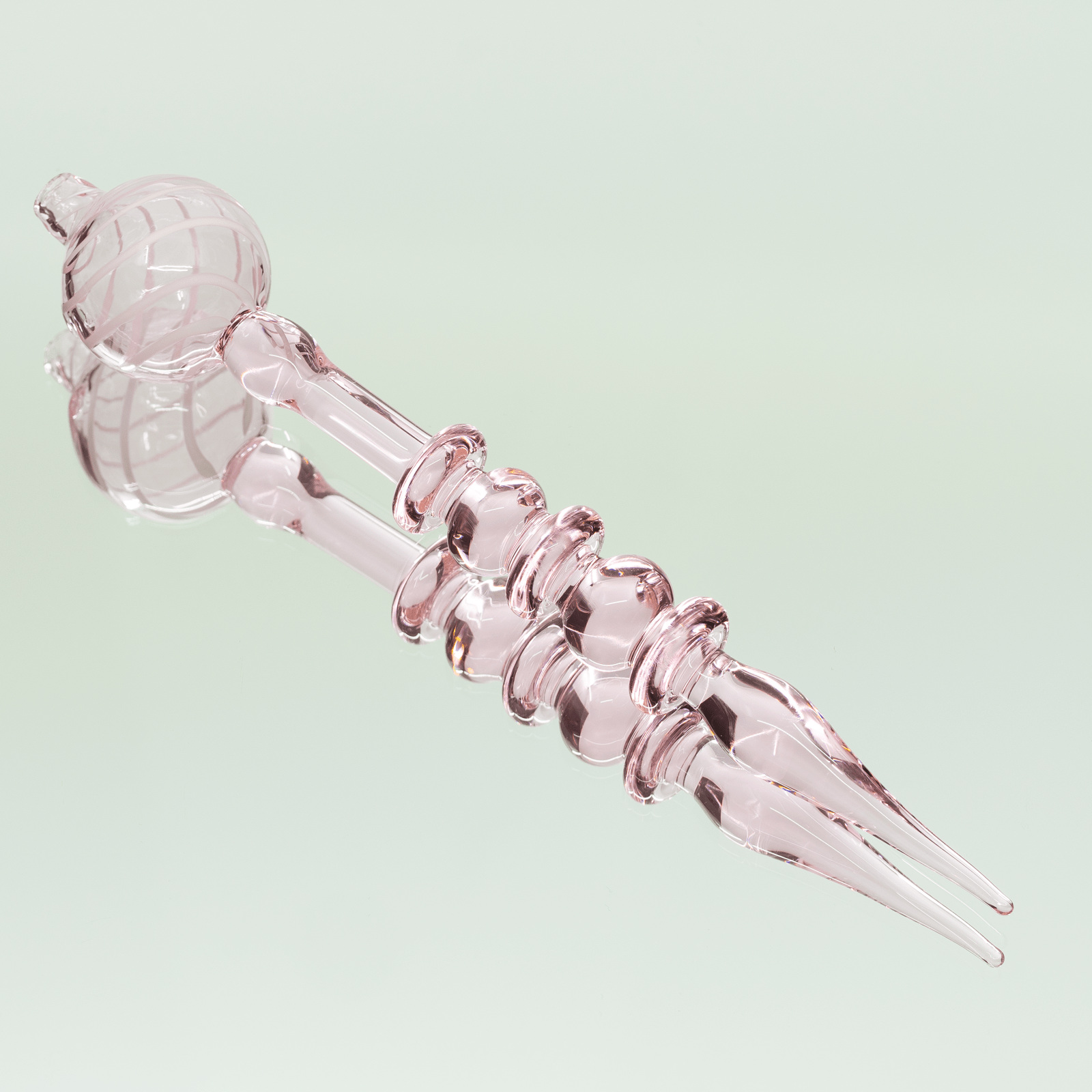 A close-up view of the Bubble Head Dab Tool & Carb Cap, displaying its curved metallic tip and rounded glass head.