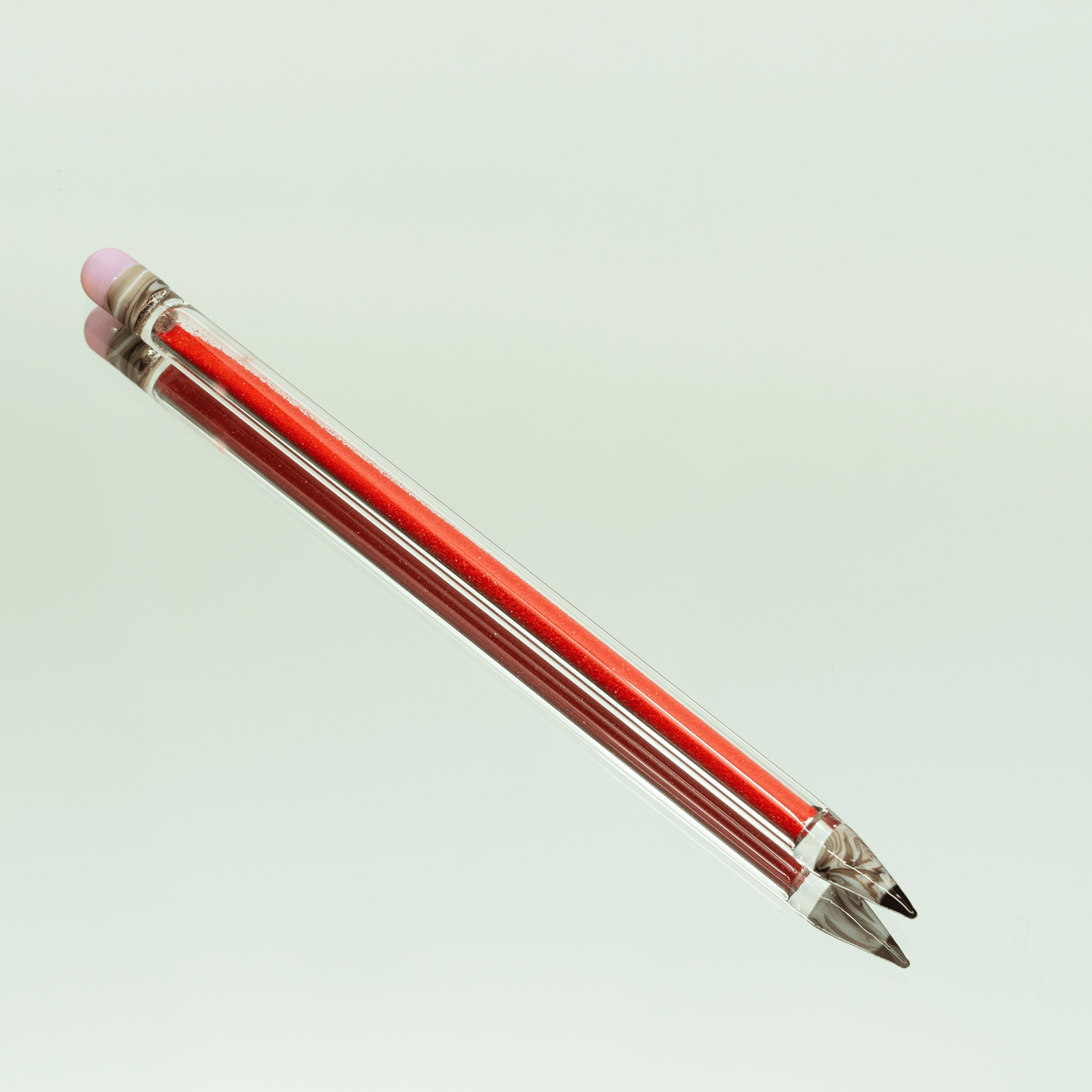 A close-up view of the Glitter Pencil Dab Tool, showing its sleek, cylindrical shape and metallic tip against a neutral backdrop.