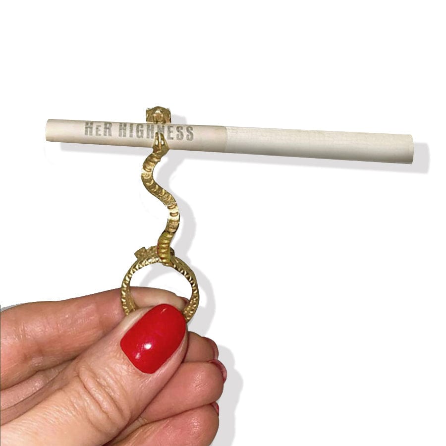 A hand displays the Snake in the Grass Joint Holder Ring, a coiled, silver-toned band encircling a lit joint.