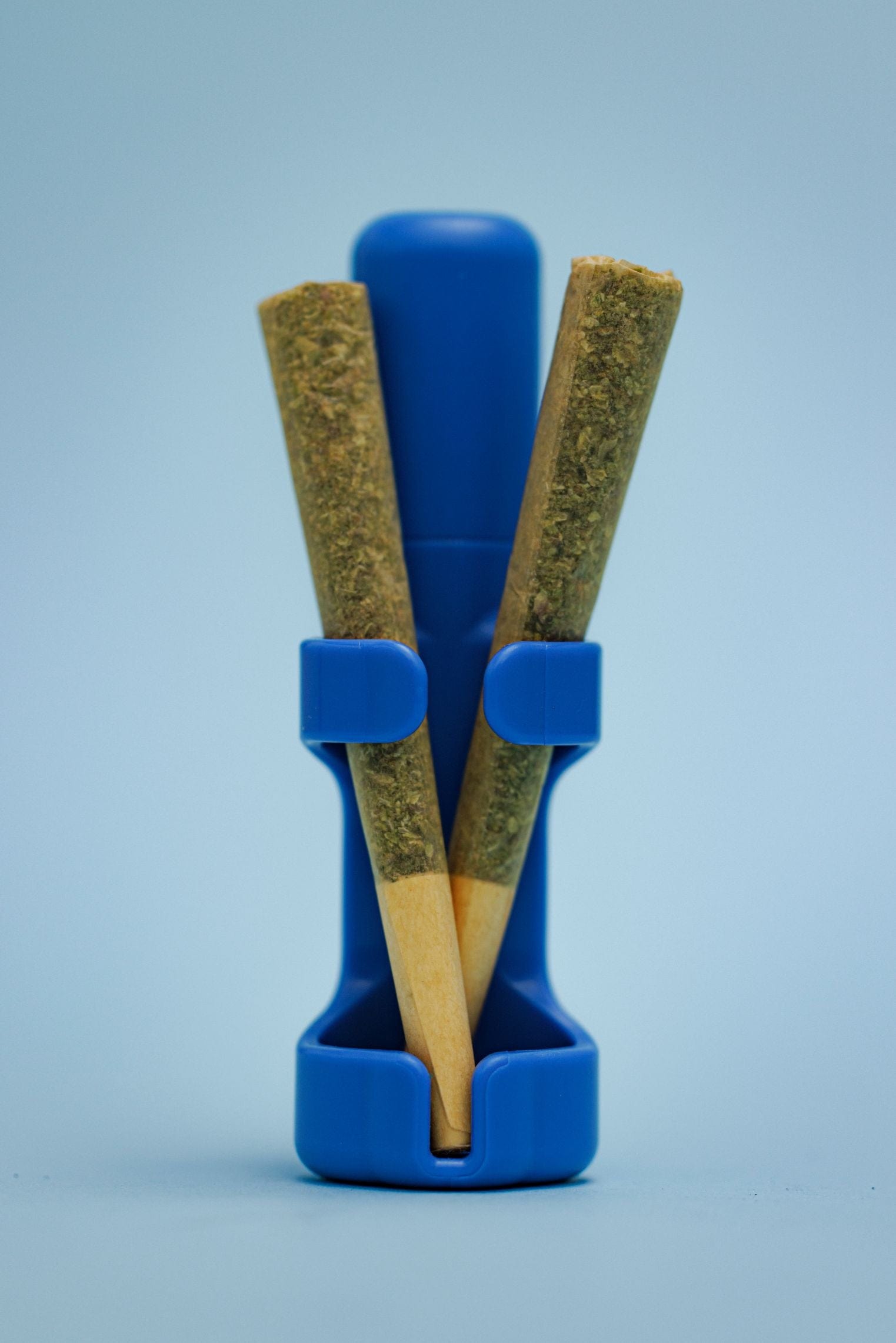 Front view of two joints held within The Clinger Stage 1 Single Joint Holder, a bright blue plastic accessory.