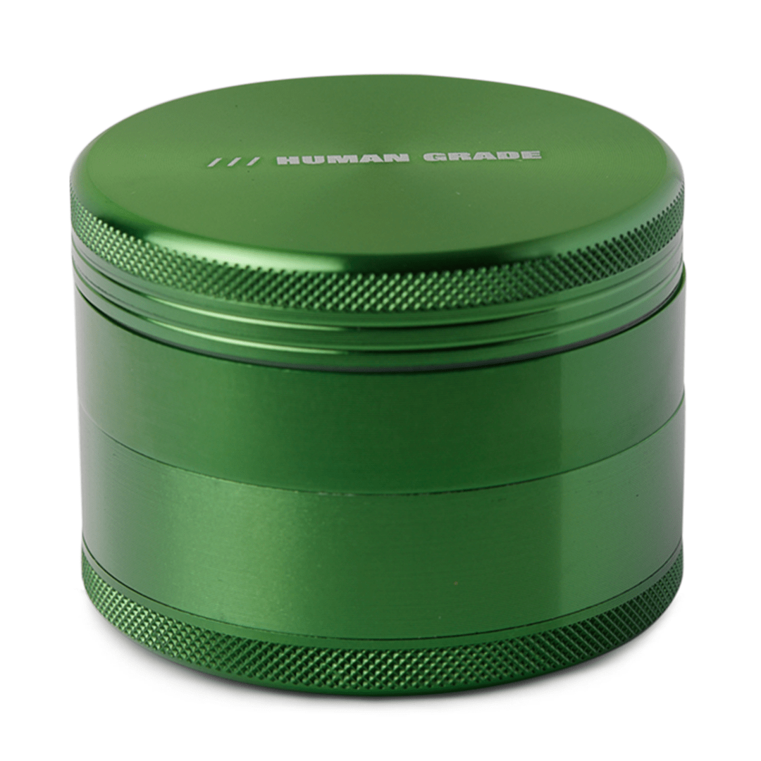 Front view of the Human Grade Grinder 1B (2.5”), a metallic green cylindrical grinder with a textured surface.