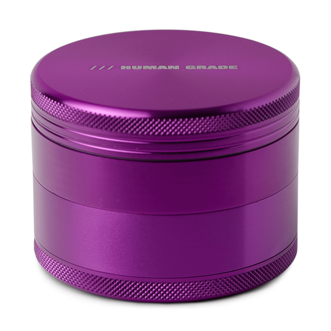 Front view of the Human Grade Grinder 1B (2.5”), a metallic purple cylindrical grinder with a textured surface.
