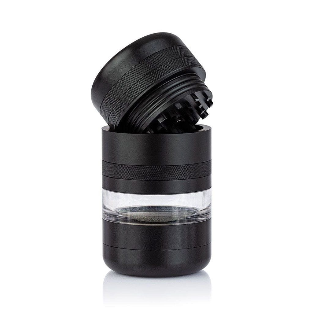Angled close-up of the black Ryot Gr8Tr Jar Body Grinder with its top half tilted to reveal textured knurling and internal teeth above a clear middle chamber