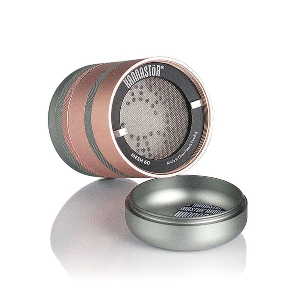 Angled close-up of the rose-gold and silver Ryot Gr8Tr Jar Body Grinder resting on its side with the lid beside it on a reflective white surface.