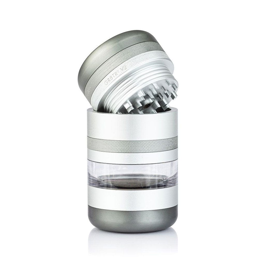 Angled close-up of the silver Ryot Gr8Tr Jar Body Grinder with its lid tilted to show internal teeth and a clear middle chamber.