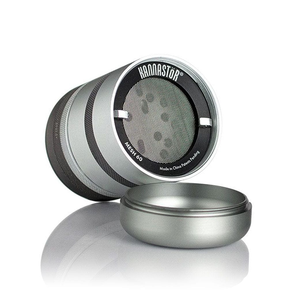 Angled close-up of the silver Ryot Gr8Tr Jar Body Grinder showing its textured rings, mesh screen and detached lid on a reflective white surface
