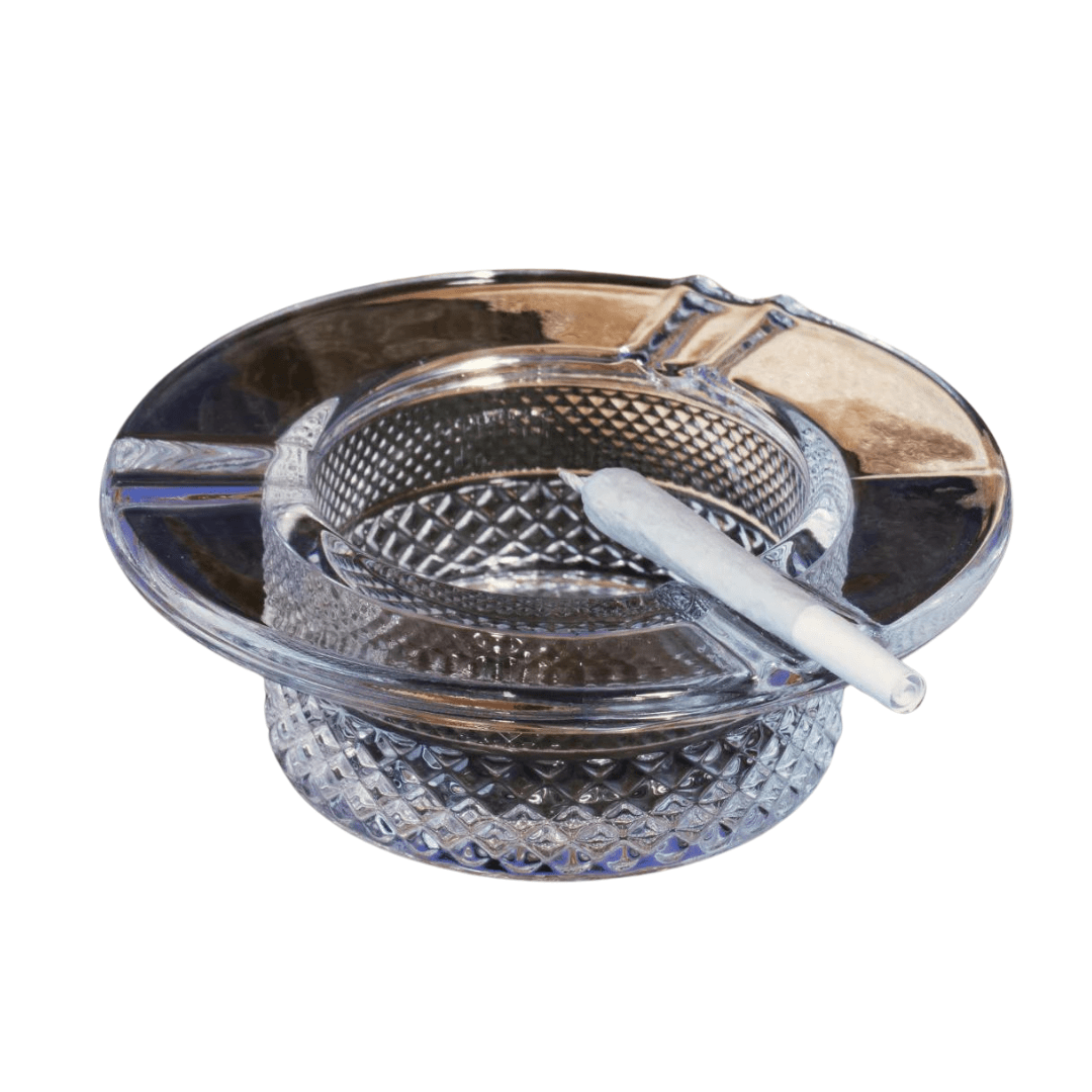 A top-down view of the Jane West Twenties Collection Ashtray, featuring a sleek, dark-colored design with a visible cigarette resting inside.