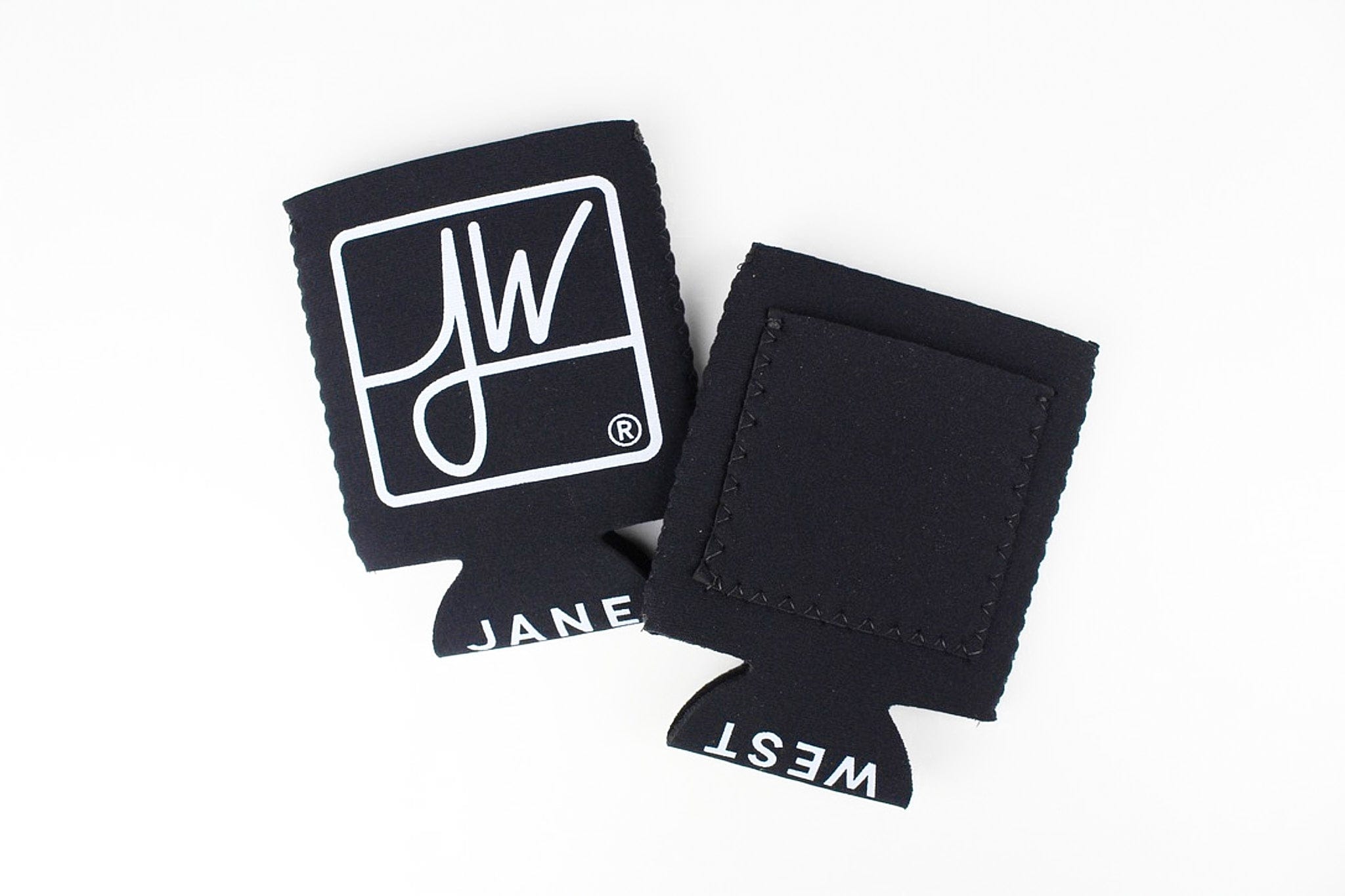 Angled top-down view of two black Jane West Koozie with Custom Pocket koozies on a white background, one showing a white JW logo and the other the stitched pocket.