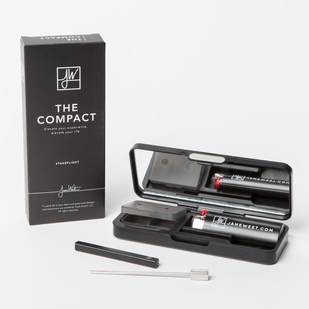 Angled shot of The Compact box and open black case with mirror showing the laid-out tools and small branded canister.