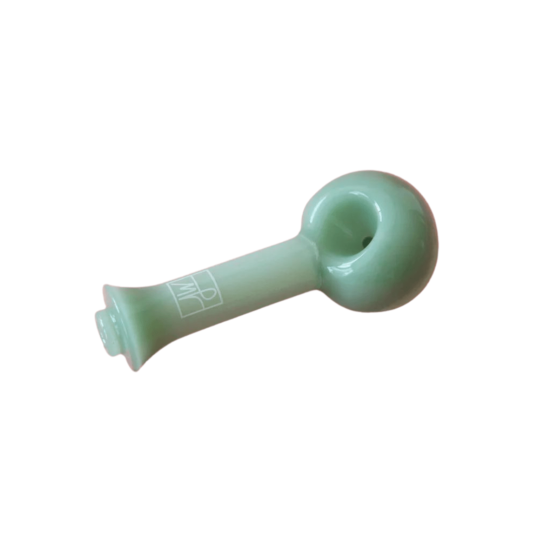 A side view of The Spoon By Jane West, a curved, green glass pipe, isolated on a white background.
