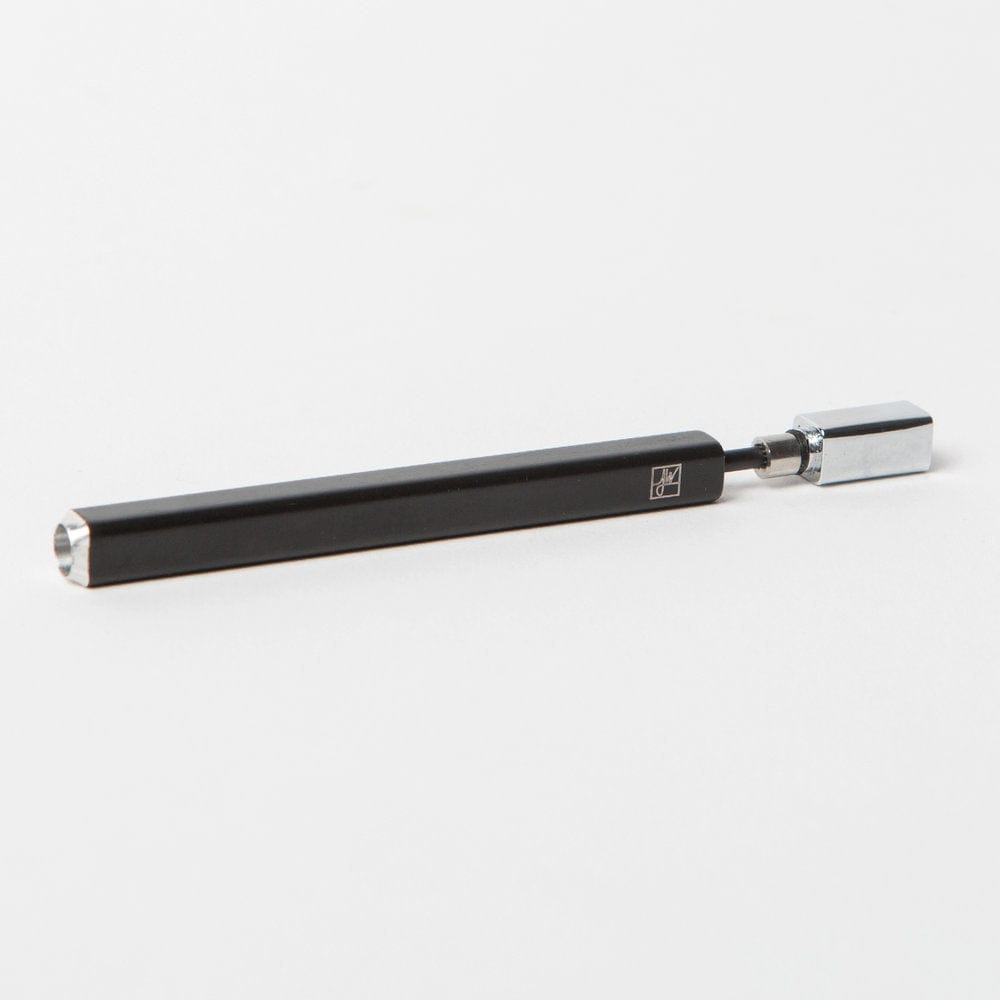 Angled close-up of The Solo showing a slim black hexagonal body with a chrome magnetic cap on a light gray background.