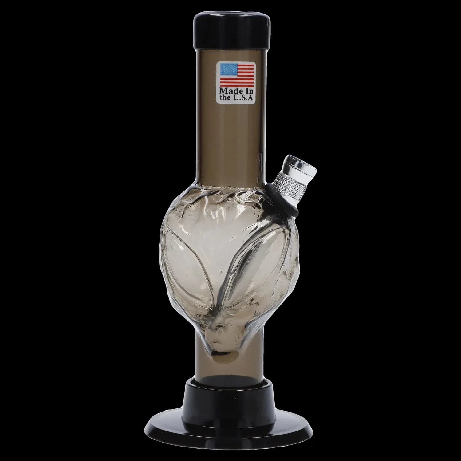 Centered close-up of the JM Plastics Mini Alien Base Acrylic Bong - 6 in. showing a smoky glass alien-head chamber and angled metal bowl against a black background