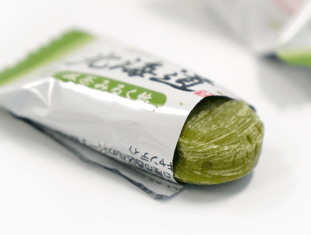 Close-up of Hokkaido Japanese Matcha Milk Candy individually wrapped in clear plastic with Japanese text.