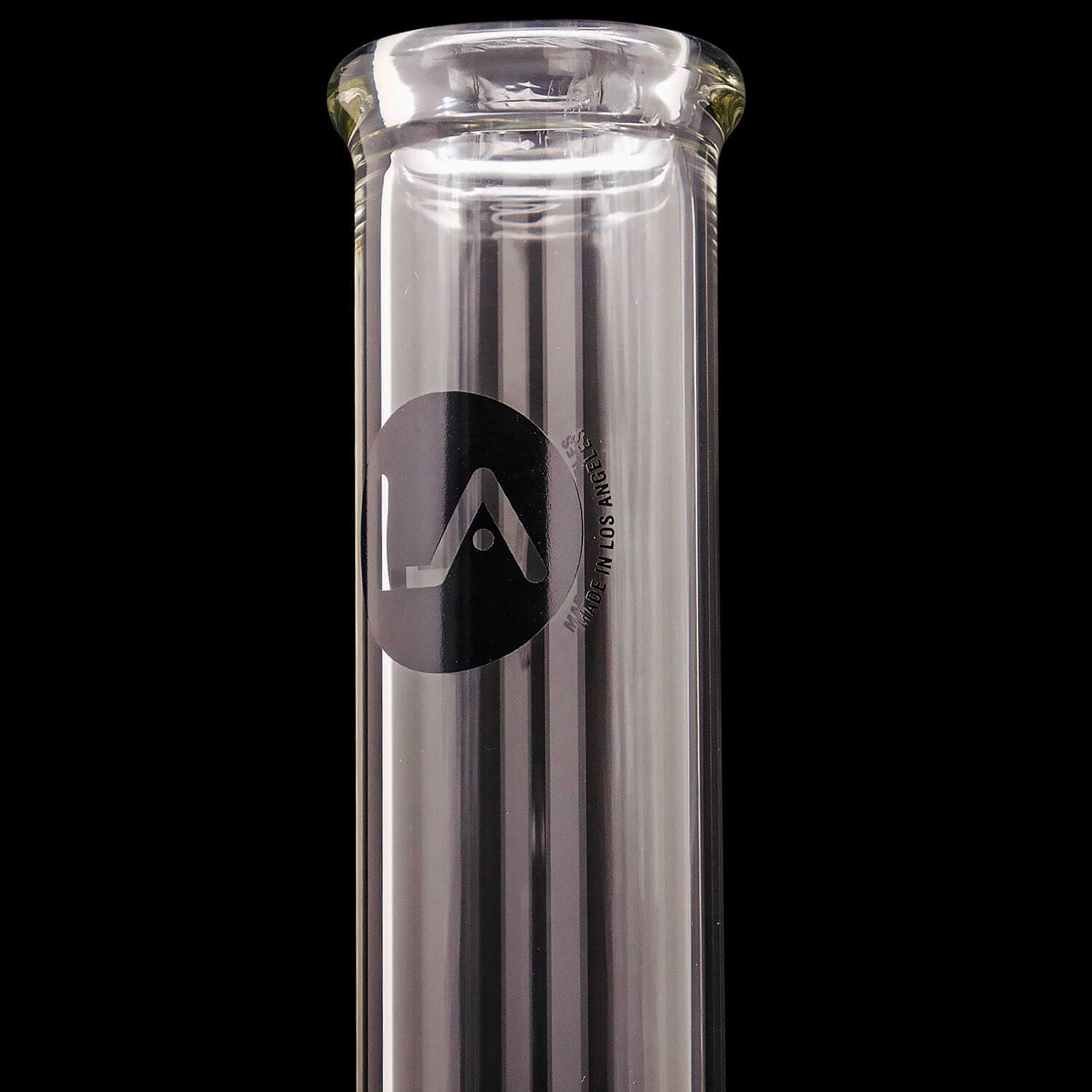 Close-up vertical shot of the clear glass "Magnum Flow" Thick Glass Beaker Showerhead Perc Bong neck showing its rounded mouthpiece and black logo against a black background