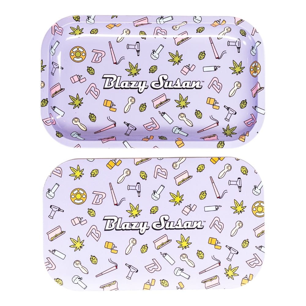 Top-down view of two lavender Blazy Susan Metal Rolling Tray pieces with scattered cartoon cannabis leaves, rolling tools, and the "Blazy Susan" logo centered.