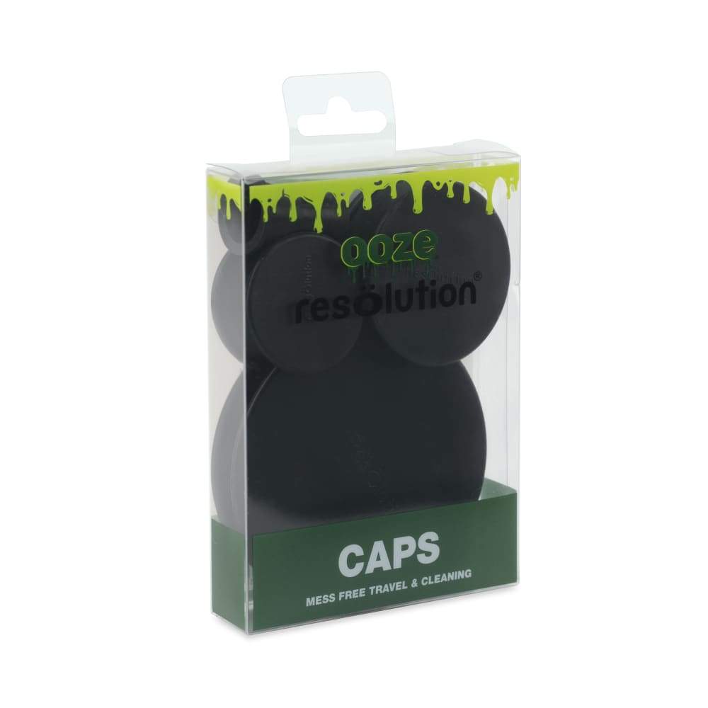 Three-quarter view of a clear hanging blister pack showing black Ooze Resolution Caps stacked inside with green header art and "CAPS" label.