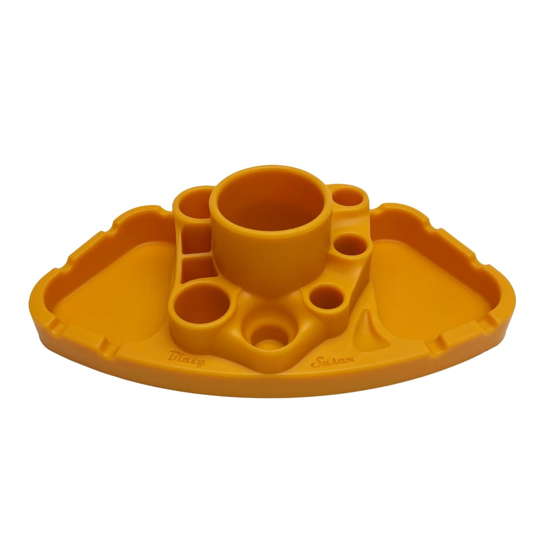 Low-angle front view of the yellow Blazy Susan Deluxe Dab Station showing its central cylindrical cup, multiple round wells and twin recessed trays on a white background