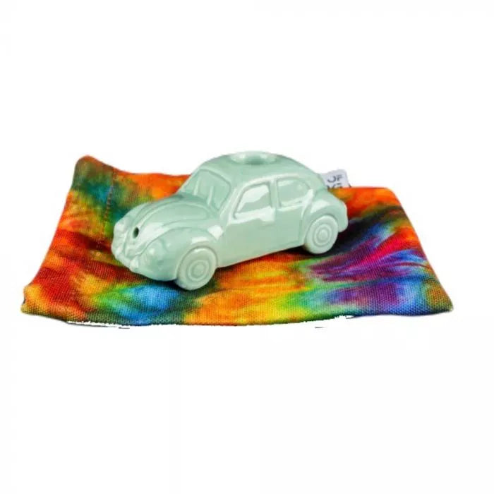 Three-quarter view of a pale mint VW Beetle Pipe resting on a colorful tie-dye cloth against a white background.