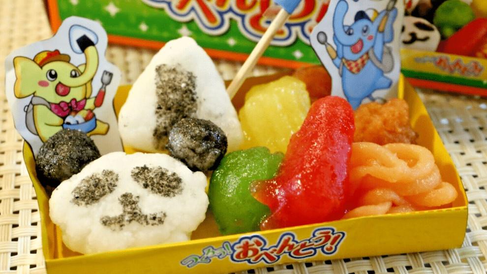 A close-up, top-down view of the “DIY Candy Making Kit - Tanoshii Bento” shows colorful, molded candies arranged on a patterned tray.