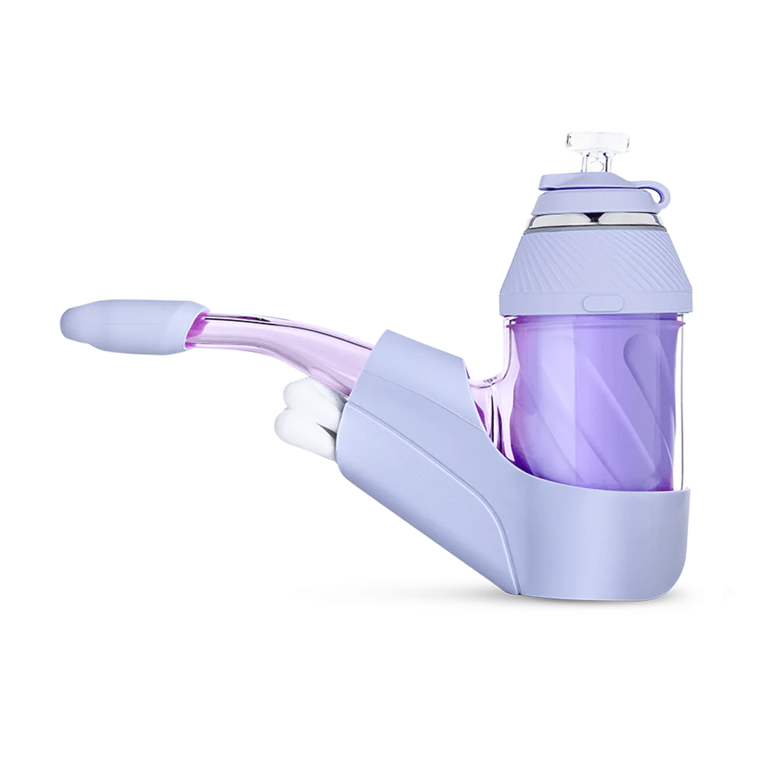 Right-side view of a desert-toned Puffco Proxy Travel Pack showing its angled pastel purple glass mouthpiece, textured cylindrical chamber, and molded silicone base on white.