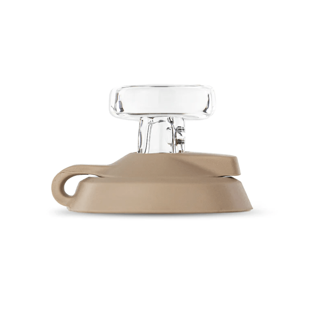Side view of a tan Puffco Proxy Carb Caps showing a clear glass top piece mounted on a rounded tan base with a small tether loop.