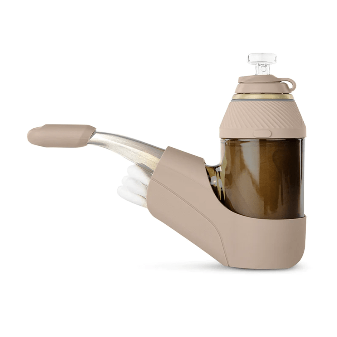 Side profile of the Puffco Proxy Travel Pack in tan, showing its angled glass mouthpiece, amber water chamber, and molded silicone travel dock.