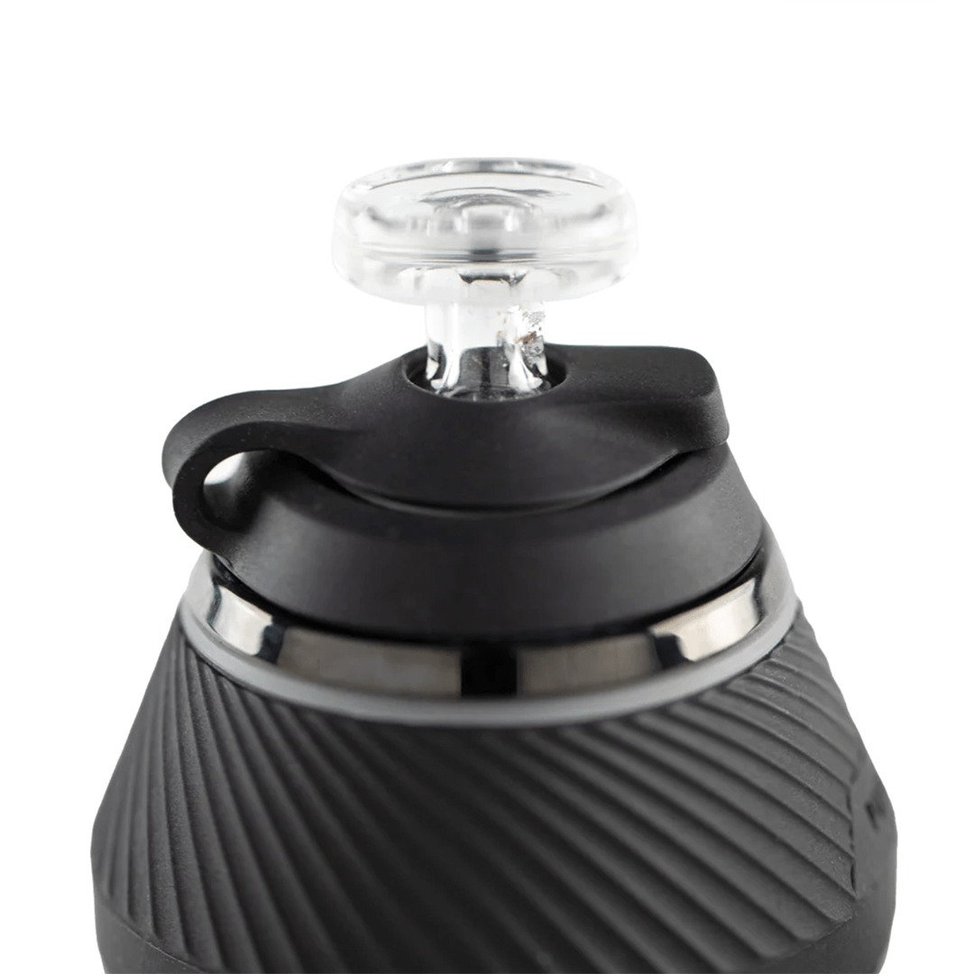 Close-up top-down view of the Puffco Proxy Travel Pack showing the clear glass mouthpiece seated in a black rubberized cap and textured matte black body.