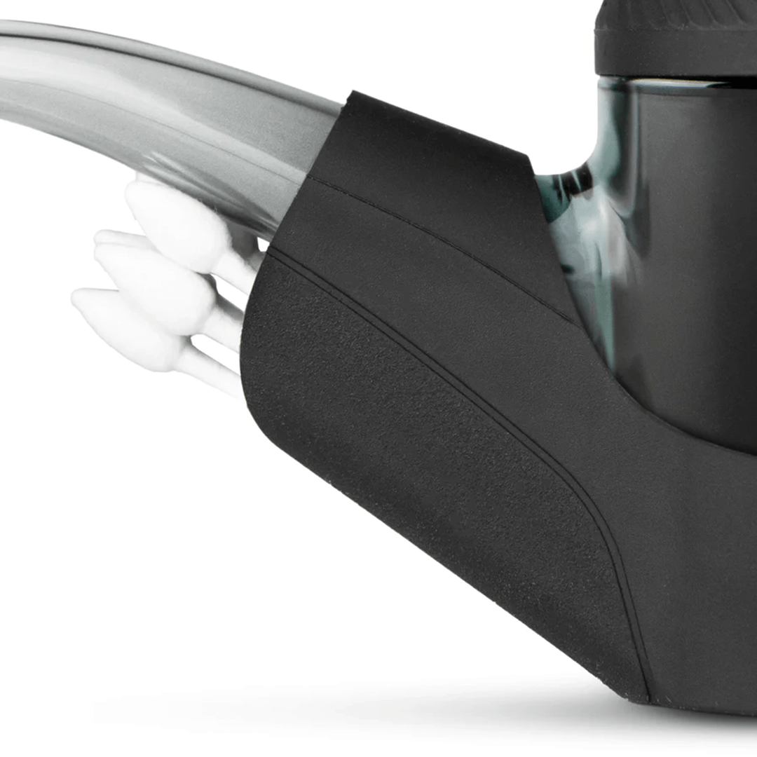 Close-up angled view of the Puffco Proxy Travel Pack showing the black textured foam base cradling a green glass chamber and a curved translucent mouthpiece.