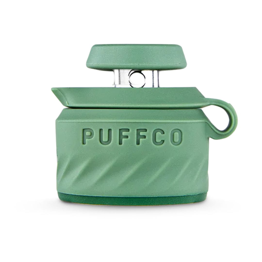 Front-facing close-up of a sage-green Puffco Peak Pro Joystick Cap showing raised "PUFFCO" lettering, textured grip, and top joystick paddle.
