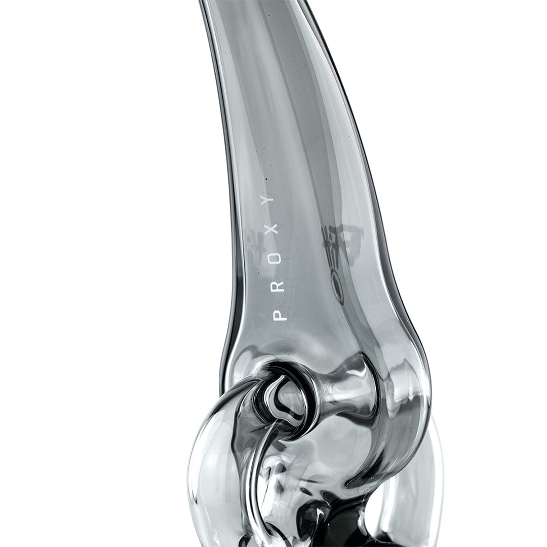Close-up angled view of the smoky glass Puffco Proxy Ryan Fitt Recycler Glass showing its curved neck, internal recycler loop, and vertical "PROXY" lettering.