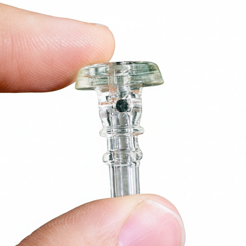 Close-up of a clear glass joystick cap held between fingertips, Empire Glassworks PuffCo Peak Pro 3D XL Chamber Glass Joystick Cap - UV Illuminnati.