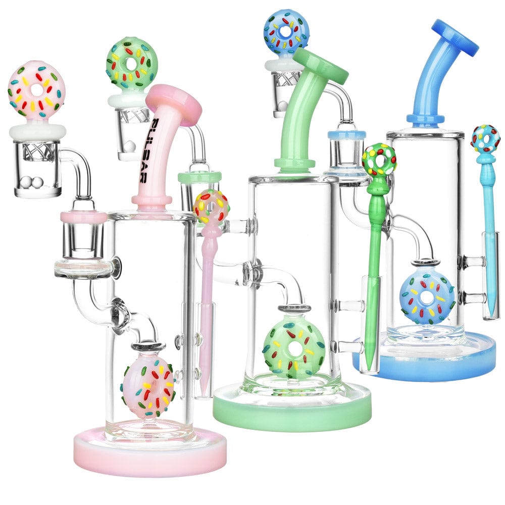 A side view of the Sprinkle Donut Dab Rig Set displays two colorful, glass dab rigs with donut-shaped accents on a white background.