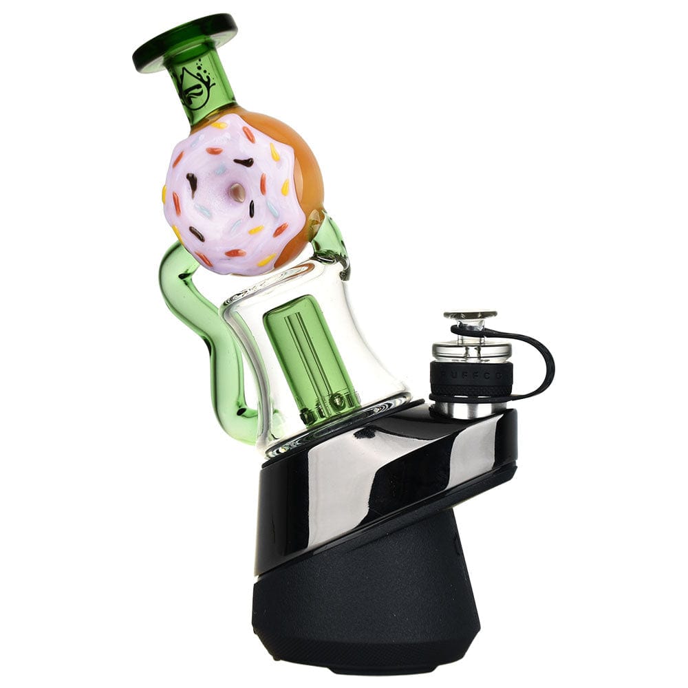 A close-up, angled view of the Donut Recycler Attachment For Puffco Peak/Pro, showcasing its colorful, glazed donut-shaped water chamber.
