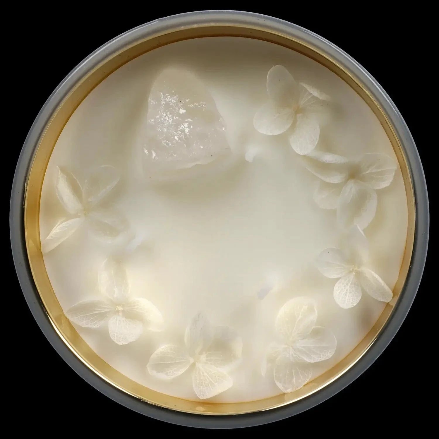 Top-down view of the Queen of Bud Candle showing a creamy wax surface with translucent flower petals and a central crystal.