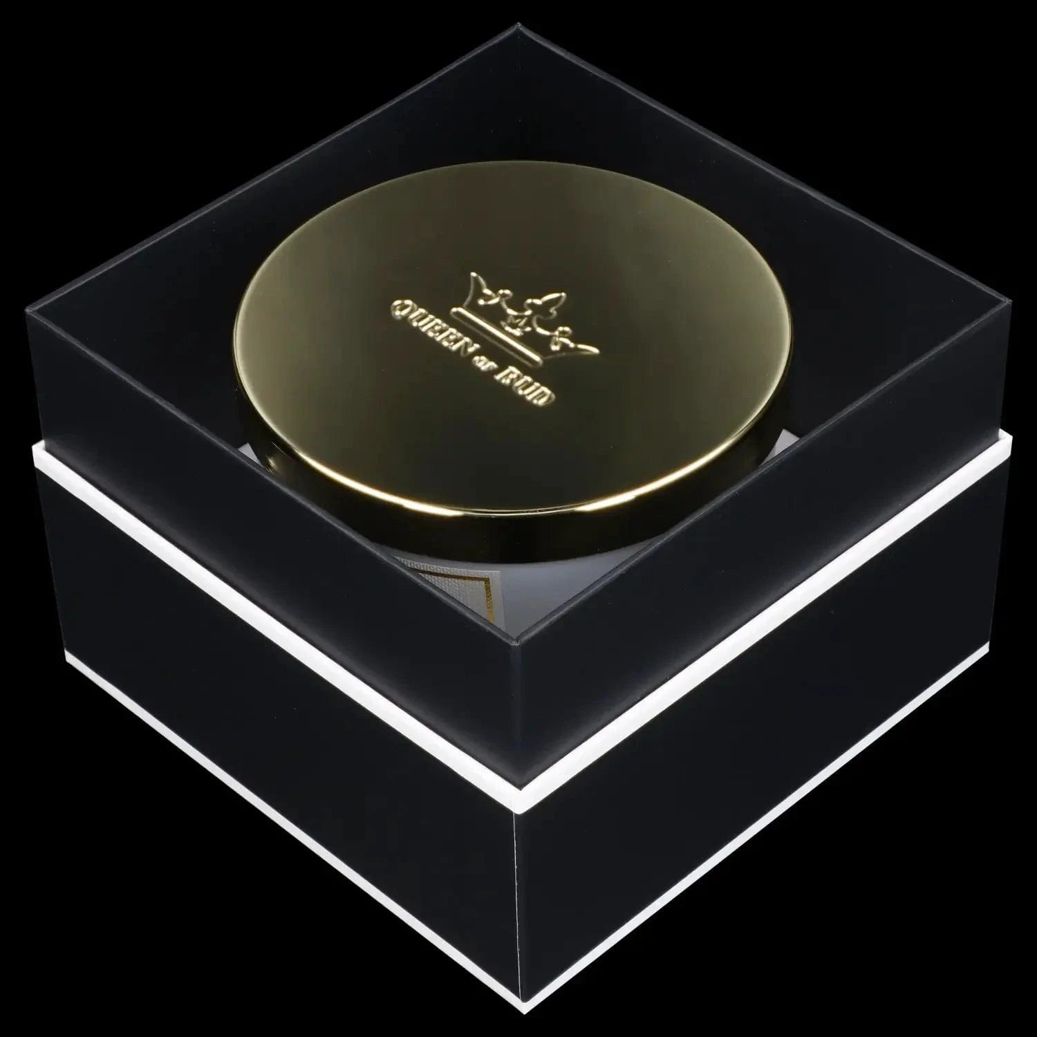 Angled close-up of the gold-lidded Queen of Bud Candle seen through a clear display box, lit to show embossed crown detail