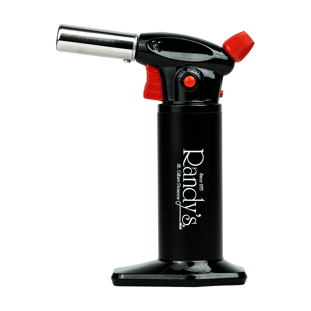 A close-up of Randy's Torch with a black handle and silver adjustment knob, angled against a dark background.