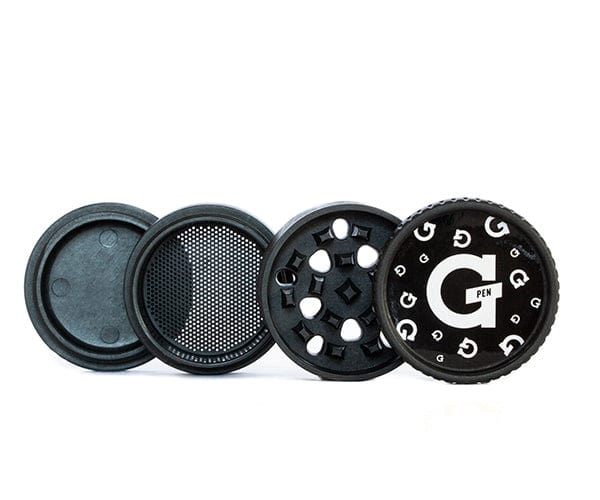 A top-down view of the disassembled Santa Cruz x G Pen Hemp Grinder, showcasing its three circular metallic pieces on a plain dark surface.