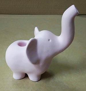 Front view of the Elephant Pipe, a small, white ceramic pipe presented on a solid green background.