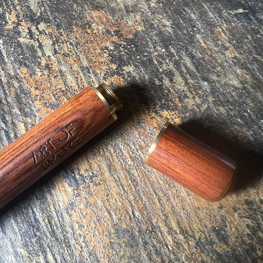 Close-up of the Rosewood Doob Tube, showing the smooth, dark wood grain against a textured background.