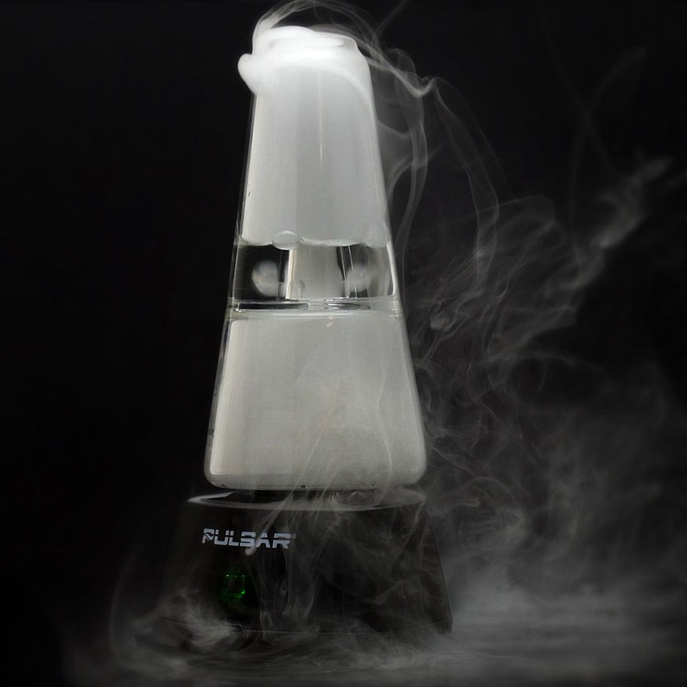 Side view of the Pulsar Sipper Wax & 510 Cartridge Vaporizer Bubbler on its black base, white glass chamber emitting swirling vapor against a dark background