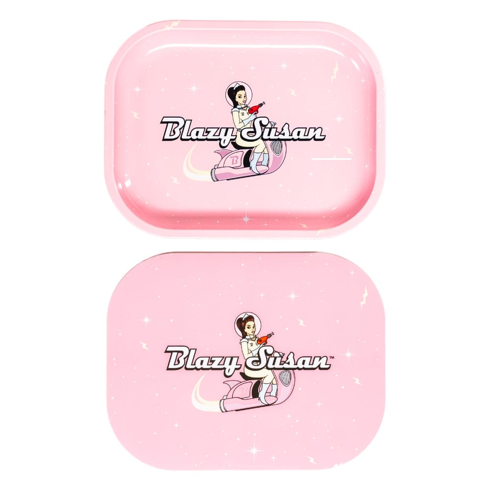 Top-down view of two pink Blazy Susan Metal Rolling Tray pieces with a retro astronaut woman logo and sparkling star accents.
