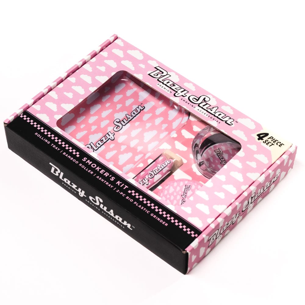 Angled top-down view of the pink, cloud-patterned Blazy Susan Blazy Smoker's Kit in its windowed retail box.