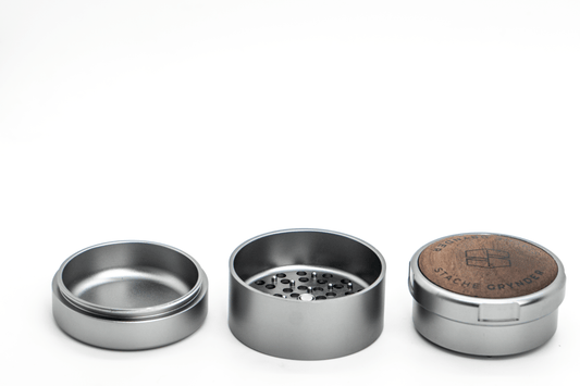 A close-up, angled view of the three-piece Grynder (N.Y.A.G) grinder, showing its silver metal construction and segmented design.