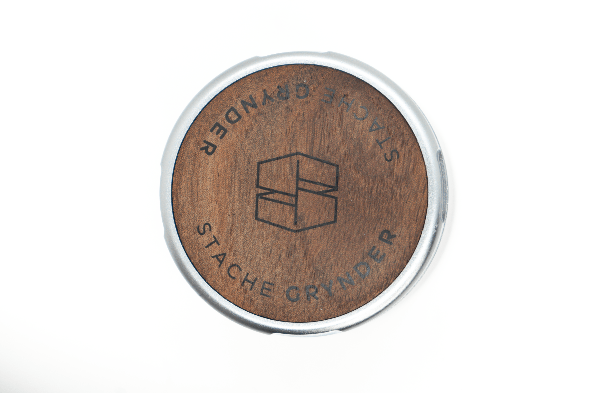 Close-up, top-down view of the Grynder (N.Y.A.G) 3-Piece, with a circular wood-grain pattern highlighting the product’s design.