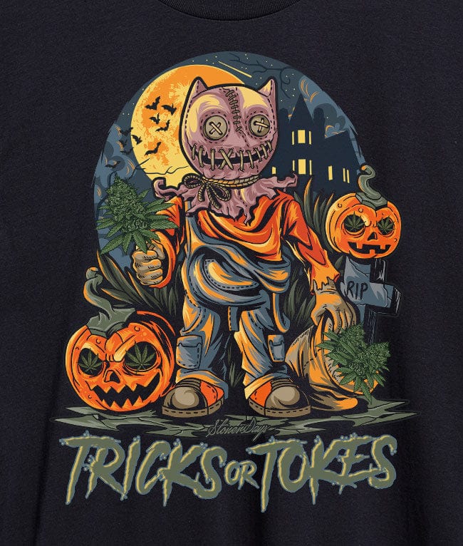 Centered front view of a stitched-cat scarecrow under a full moon holding marijuana sprigs, graphic on a black "Trick or Tokes Tee" shirt.